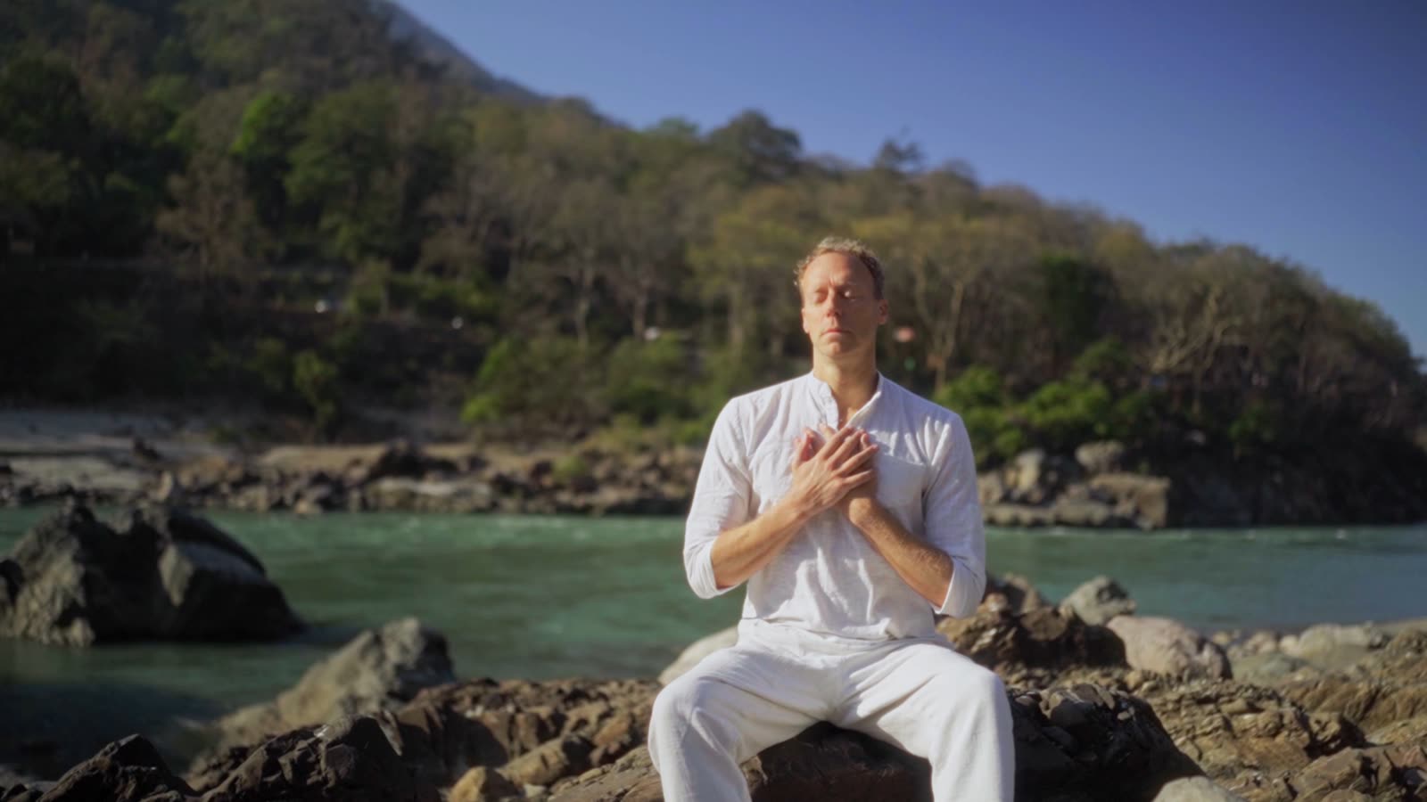 Tomas Stendahl by a river with his hands on his heart