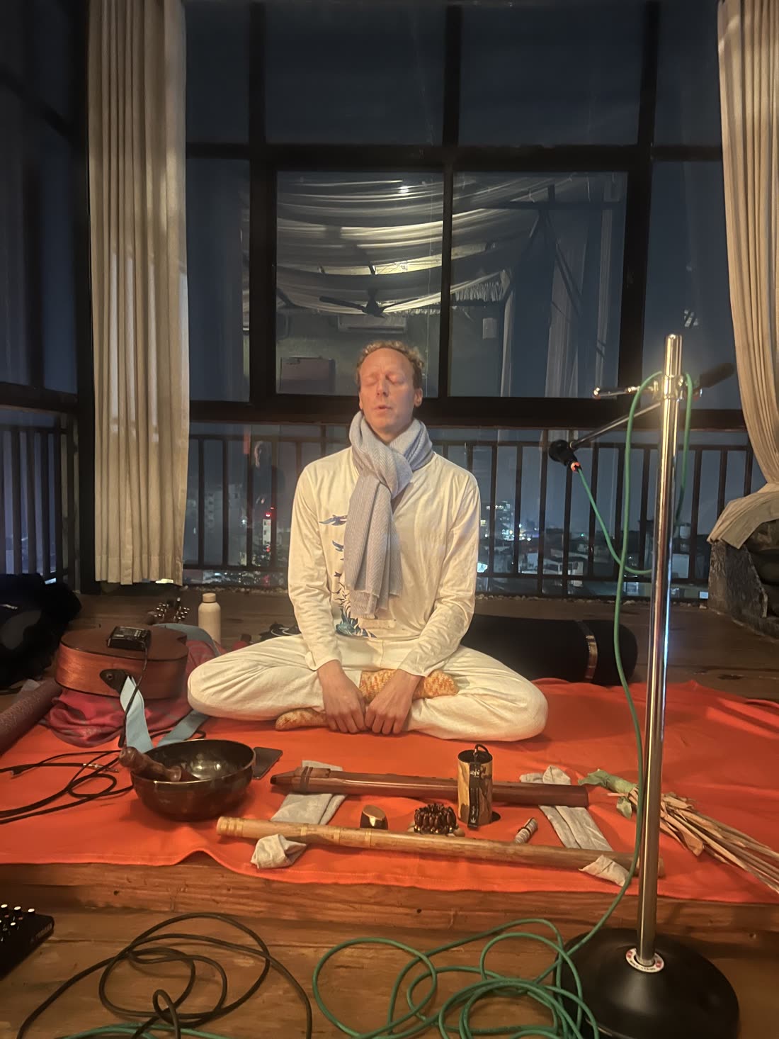 Tomas sitting cross-legged among his instruments, ready to lead a sound session